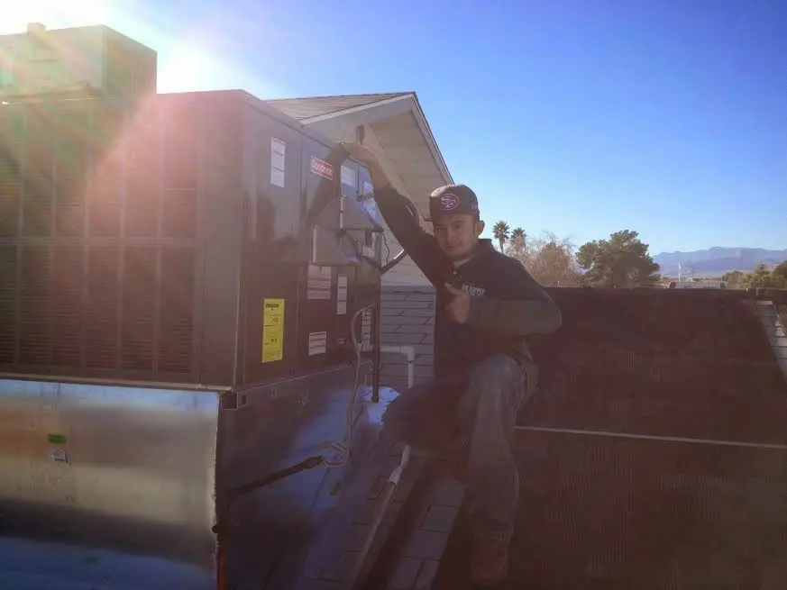 HVAC technician performing HVAC Inspection on a rooftop unit in Rincon